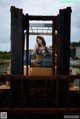 A woman sitting in the driver's seat of a forklift.